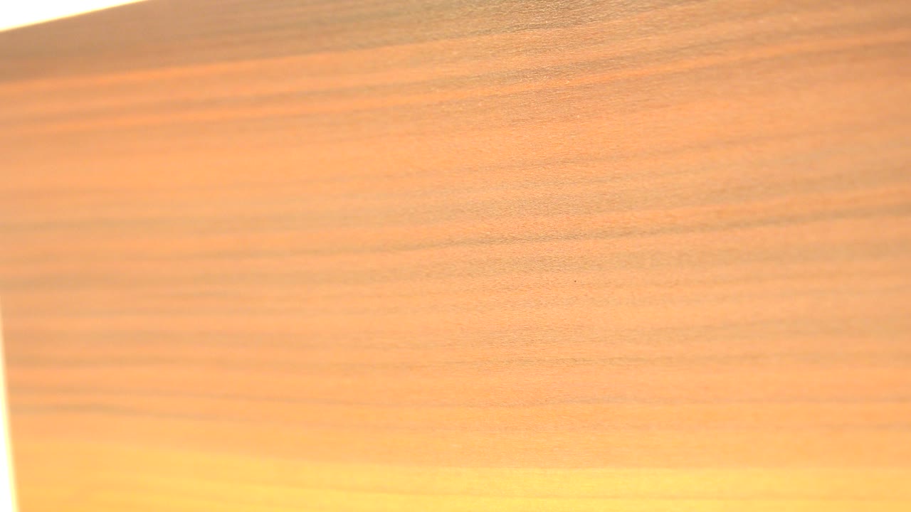 Close view of tan wood grain in Westminster, Colorado footage with a bright overexposed vertical edge at the left side and no visible people.