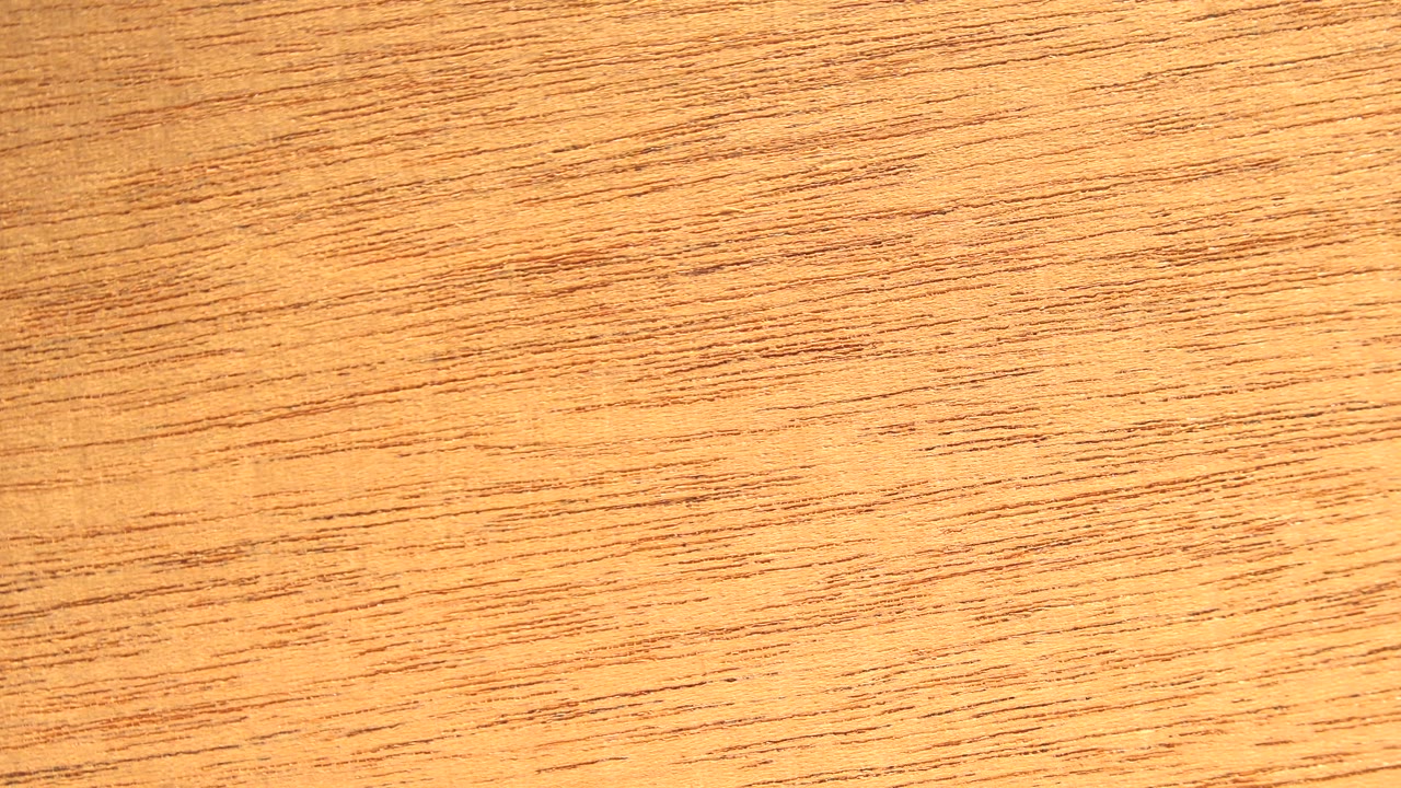 A bright white vertical band and yellow-orange reflective area cut across the wood texture, with no visible people.