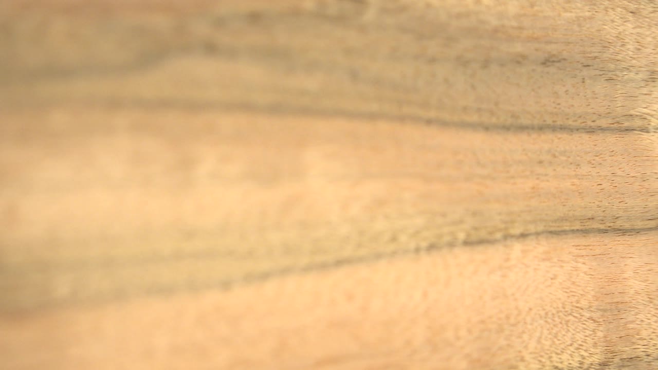 The wooden panel fills the Westminster frame with warm honey color, darker grain streaks, and no visible people or readable markings.