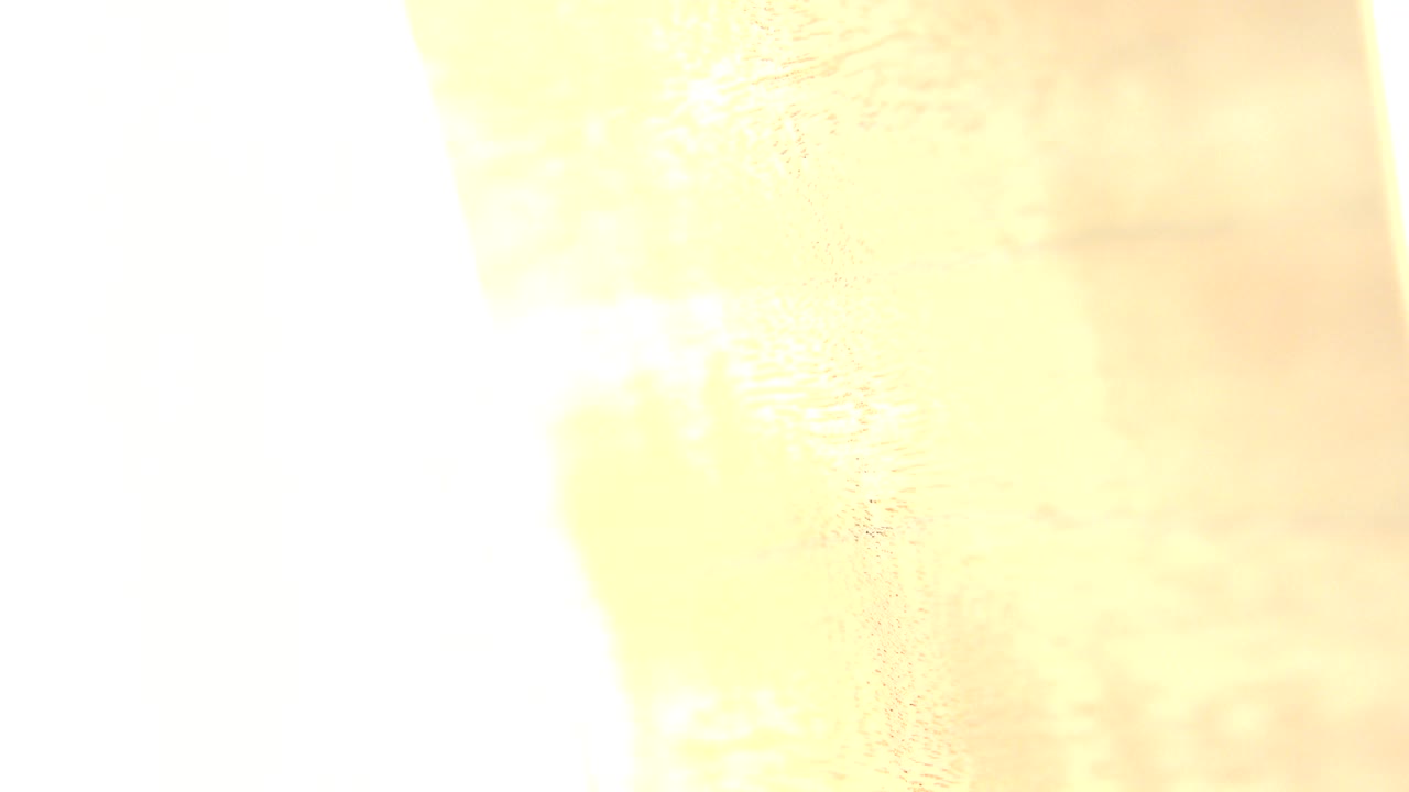 A close wood surface appears under strong yellow-white light in Westminster, Colorado footage, with no visible people.