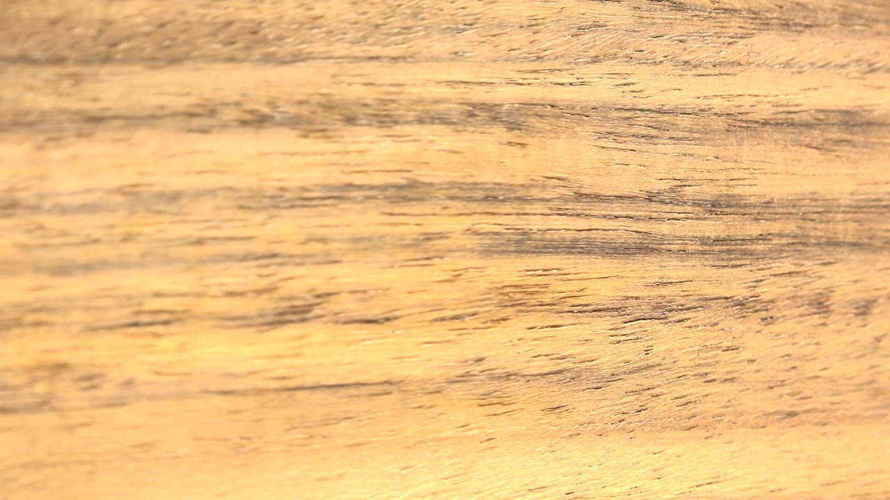 Close abstract view of a tan and brown rock or mineral texture in Westminster, Colorado, with dark streaks across the surface and no visible people.