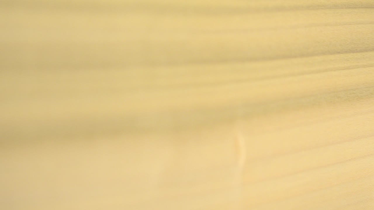 Opening frame of a warm tan and brown abstract surface in Westminster, Colorado, with soft horizontal grain-like bands and no visible people.