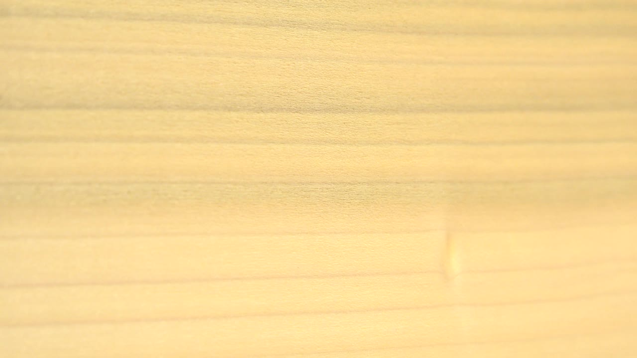 Yellow plate-like surface across a pale wood background.