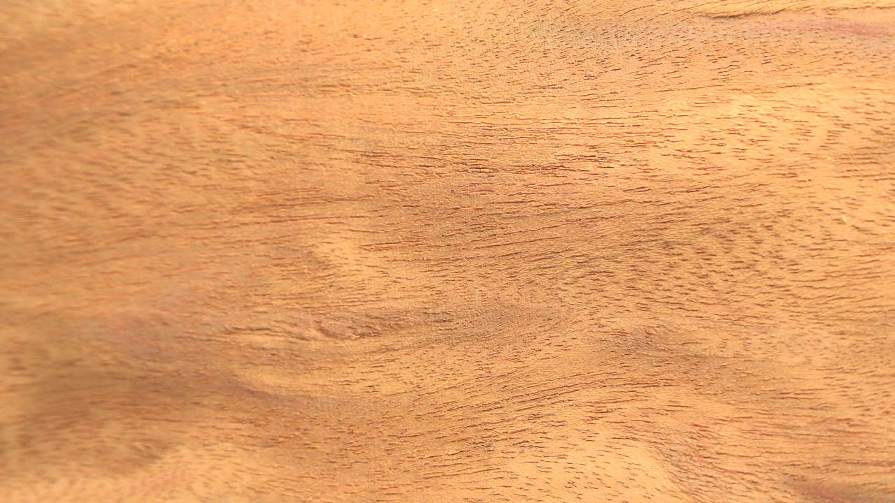 A close wood surface fills the Westminster, Colorado frame, with bright warm light washing across the upper area and no visible people.