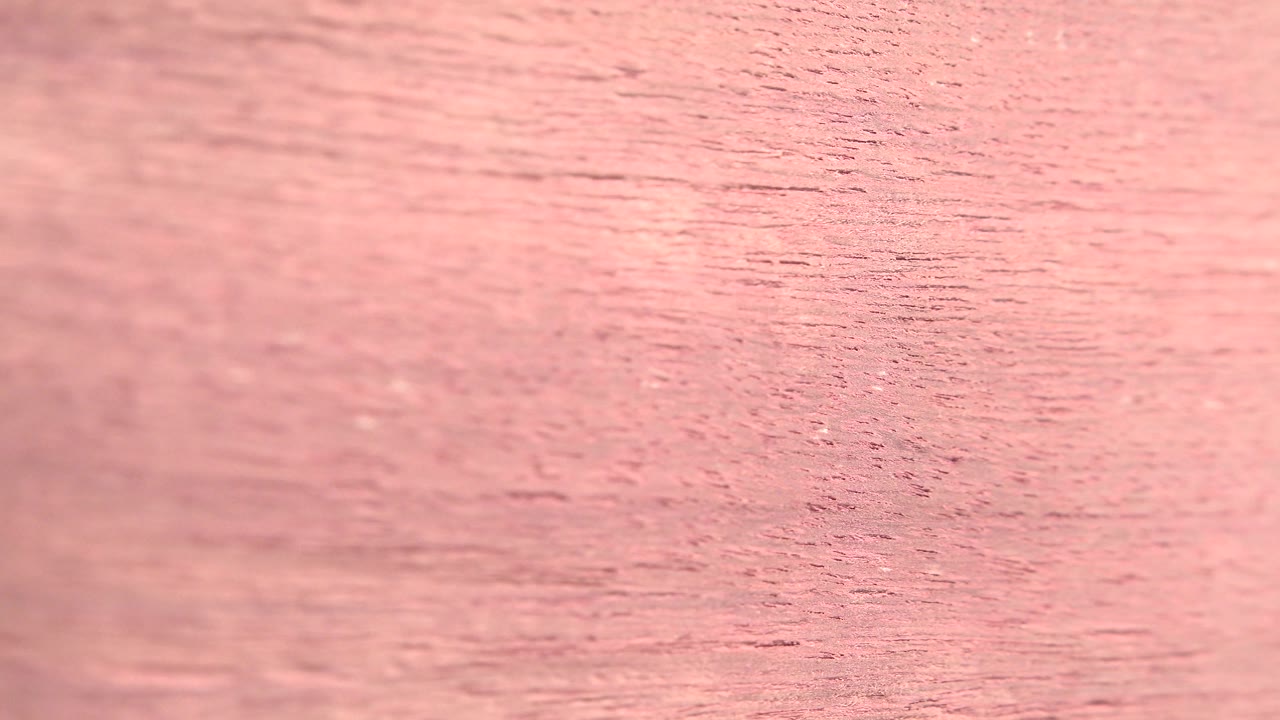 Close view of pink wood grain filling the frame.