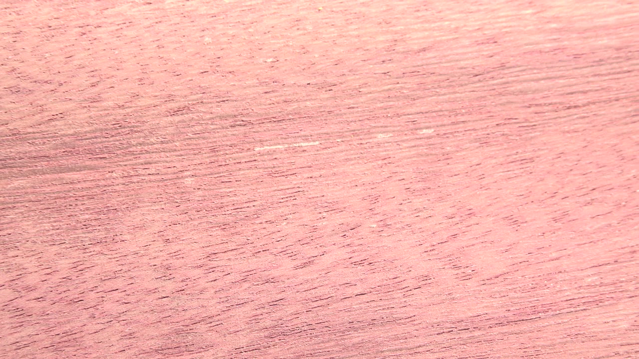 Close-up pink-tan fibrous material surface from the Westminster, Colorado 2015 clip, with diagonal grain marks and no visible people.