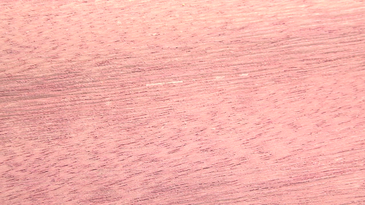 A close view of the fibrous sheet in Westminster, Colorado, showing pink-tan grain with a brighter pale band near the top and no visible people.