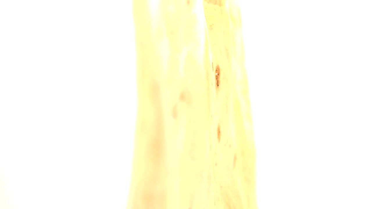 At 0:01, the frame remains mostly white from strong exposure, with a slim yellow wood edge and faint dark specks visible, no visible people.