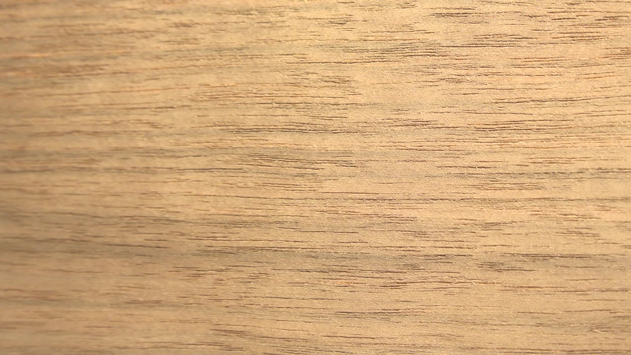Close yellow and brown plywood grain fills the frame in Westminster, Colorado footage, with no visible people.