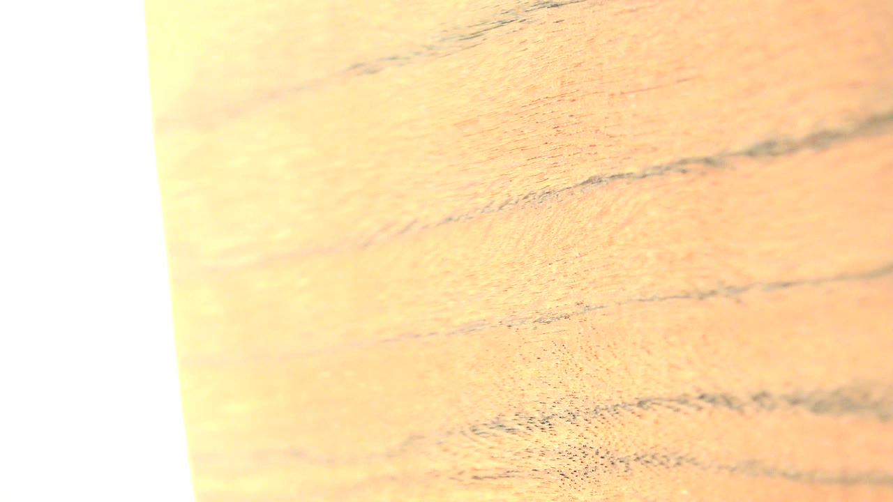 Close-up tan wood grain with a bright white vertical edge.