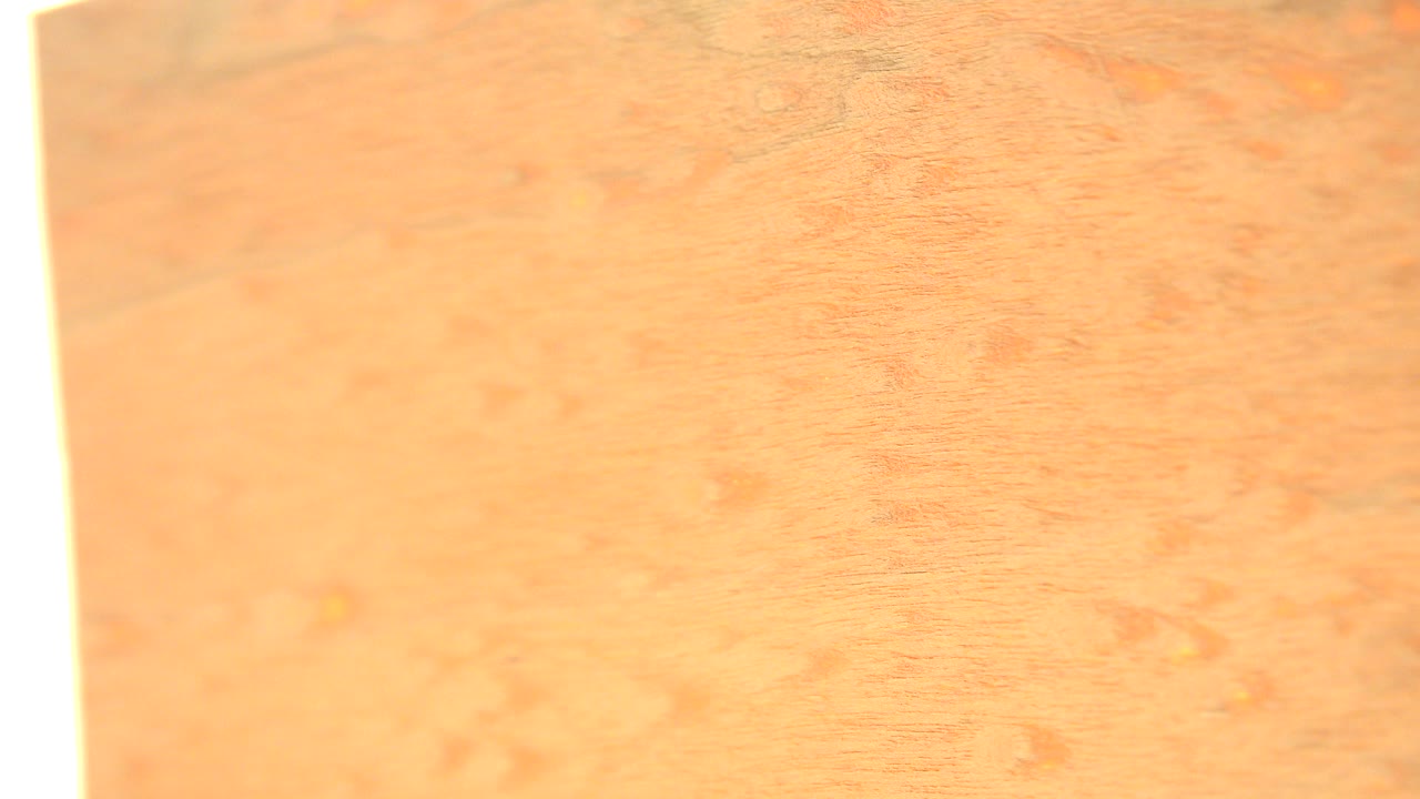 At 0:00, a close Westminster, Colorado frame shows orange-brown wood grain with an overexposed white edge along the left side and no visible people.