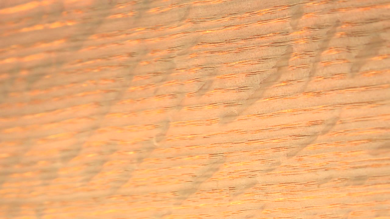 Blurred warm texture with diagonal bands and orange highlights.