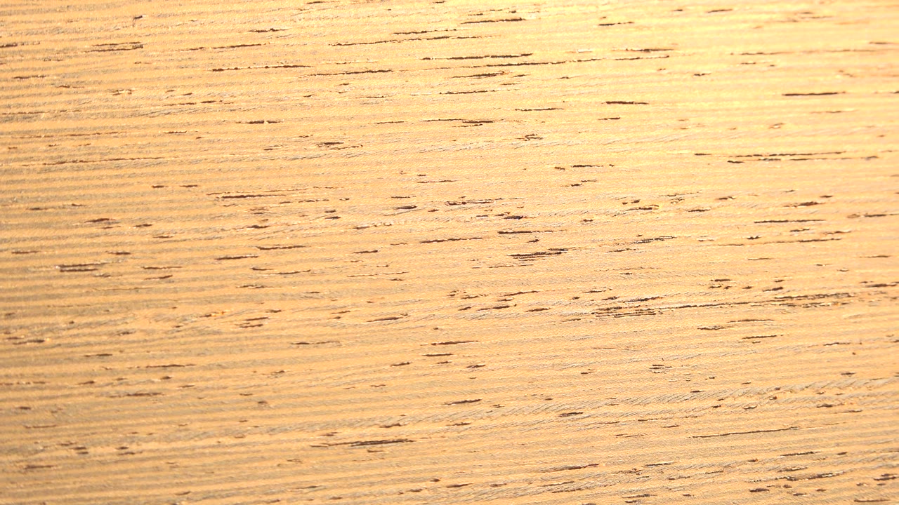 The second frame shows the fibrous sheet closer to center, with fine horizontal lines and small dark specks visible, no visible people.