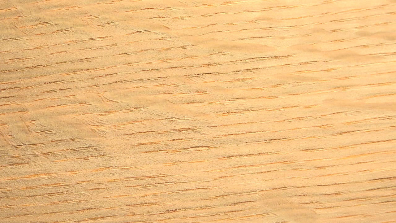 Close view of tan wood grain in Westminster, Colorado, with warm horizontal lines across the board surface and no visible people.