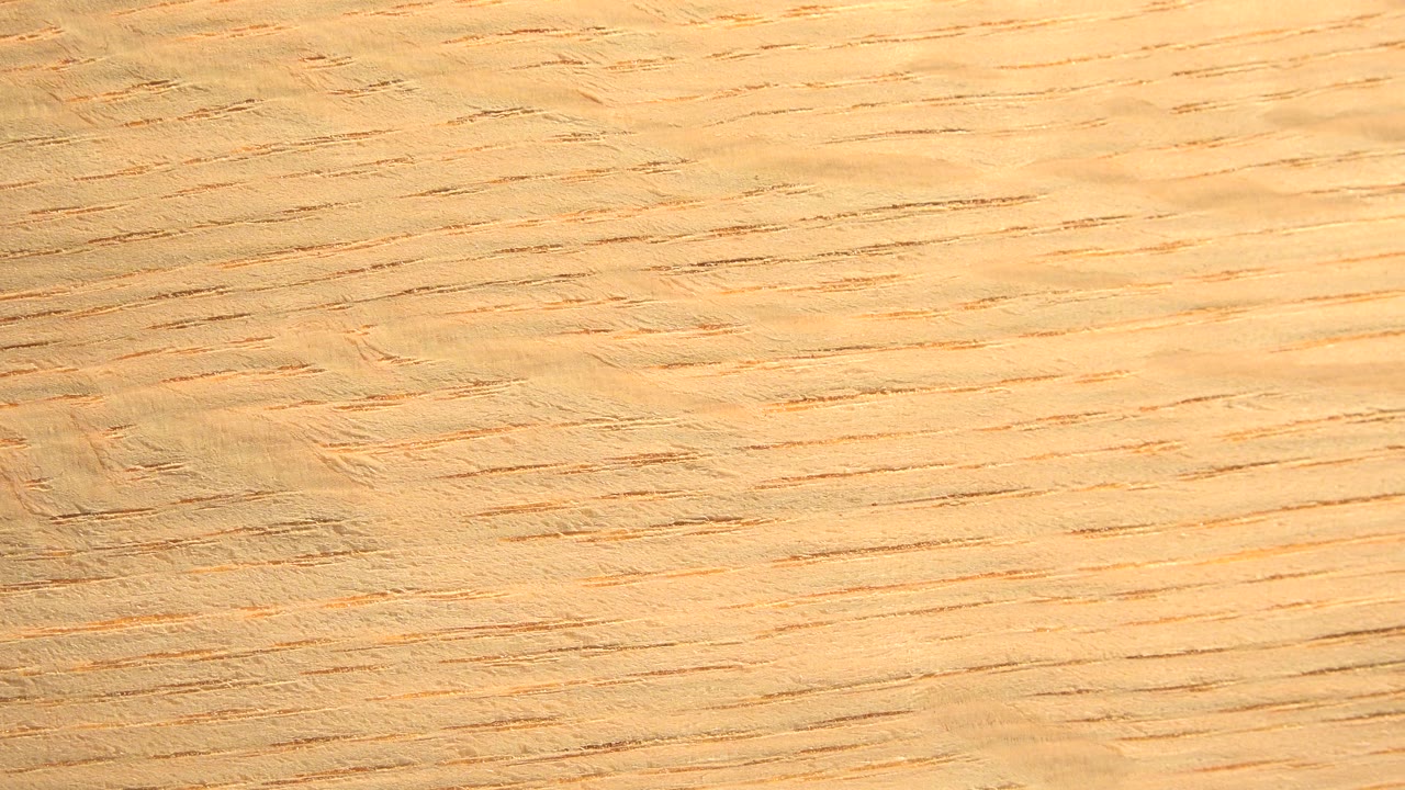 Close frame of the rotating wooden board in Westminster, Colorado, with the grain angle slightly changed and no visible people.