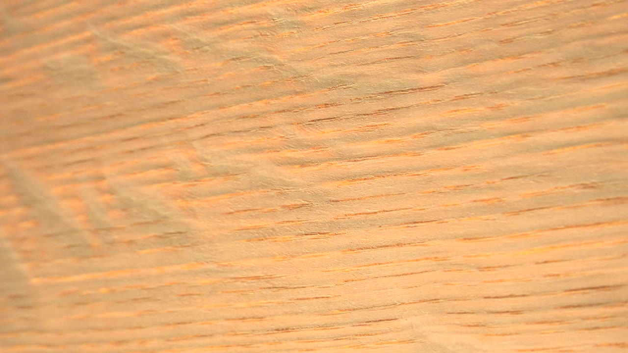 Close tan wood surface with a softer vertical band through the frame.