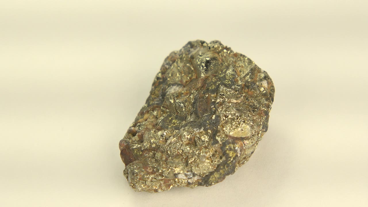 Rough metallic stone on a pale surface.