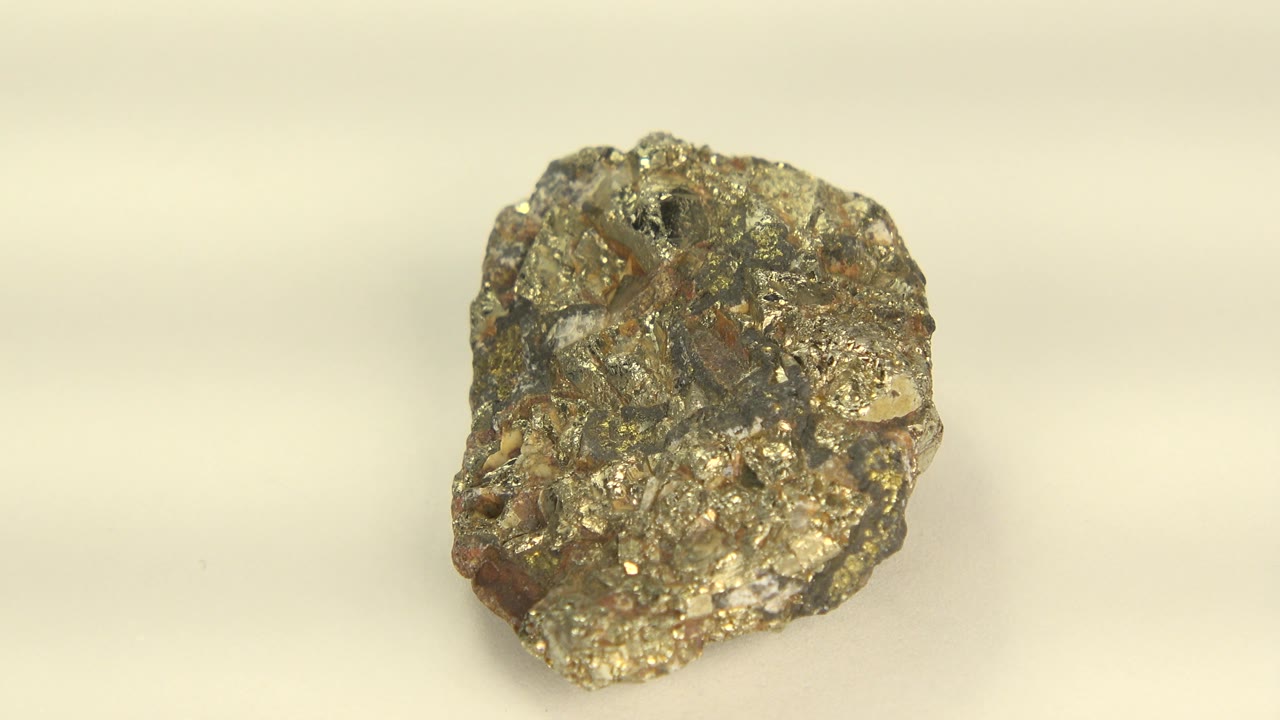 The stone is shown in a more upright angle on a pale background, showing craggy gold-gray surfaces and no visible people.