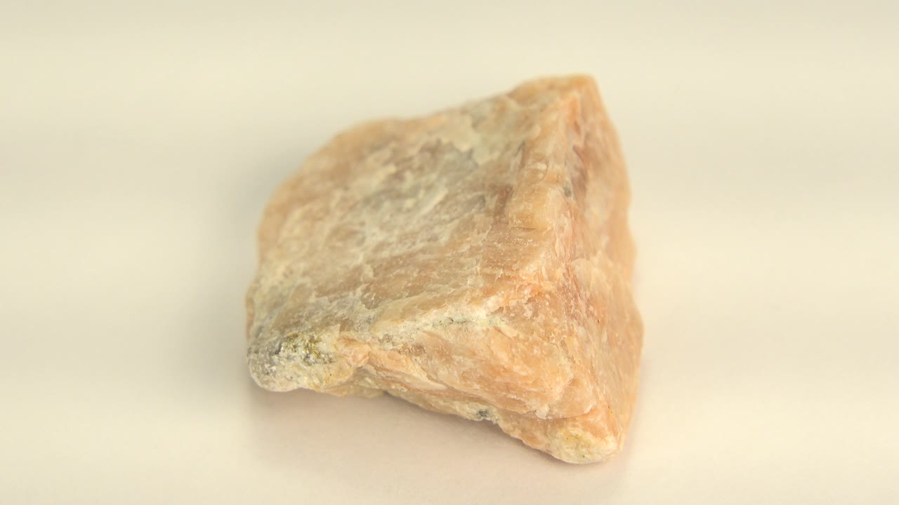 Small orange and yellow sandstone rock against a plain background