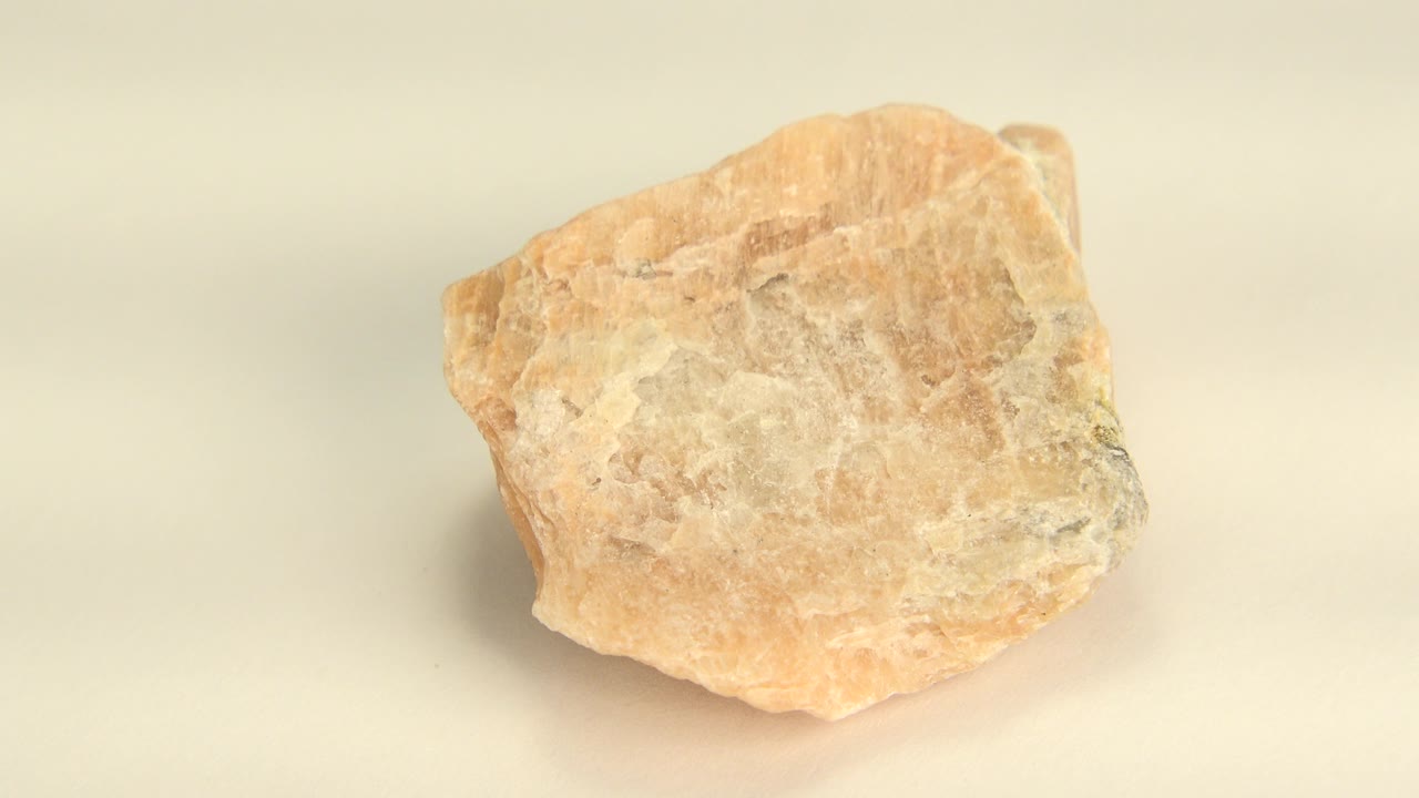 The orange rock remains centered on the pale table in Westminster, Colorado, showing a slightly different face and no visible people.