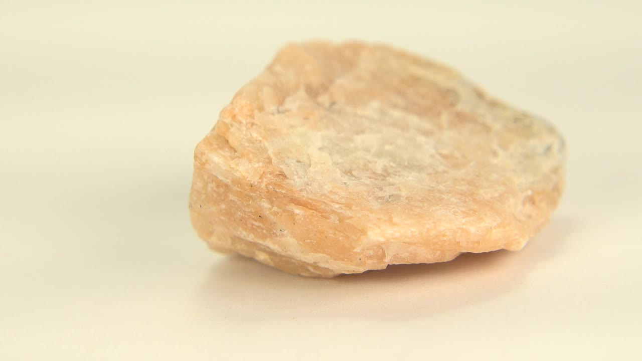 Tan rock angled slightly on a cream background.