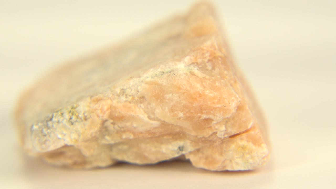 A tan-orange rough stone sits in close-up on a pale background in Westminster, Colorado, with no visible people.