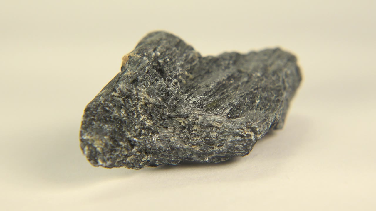 Black rock on a pale surface in close-up.