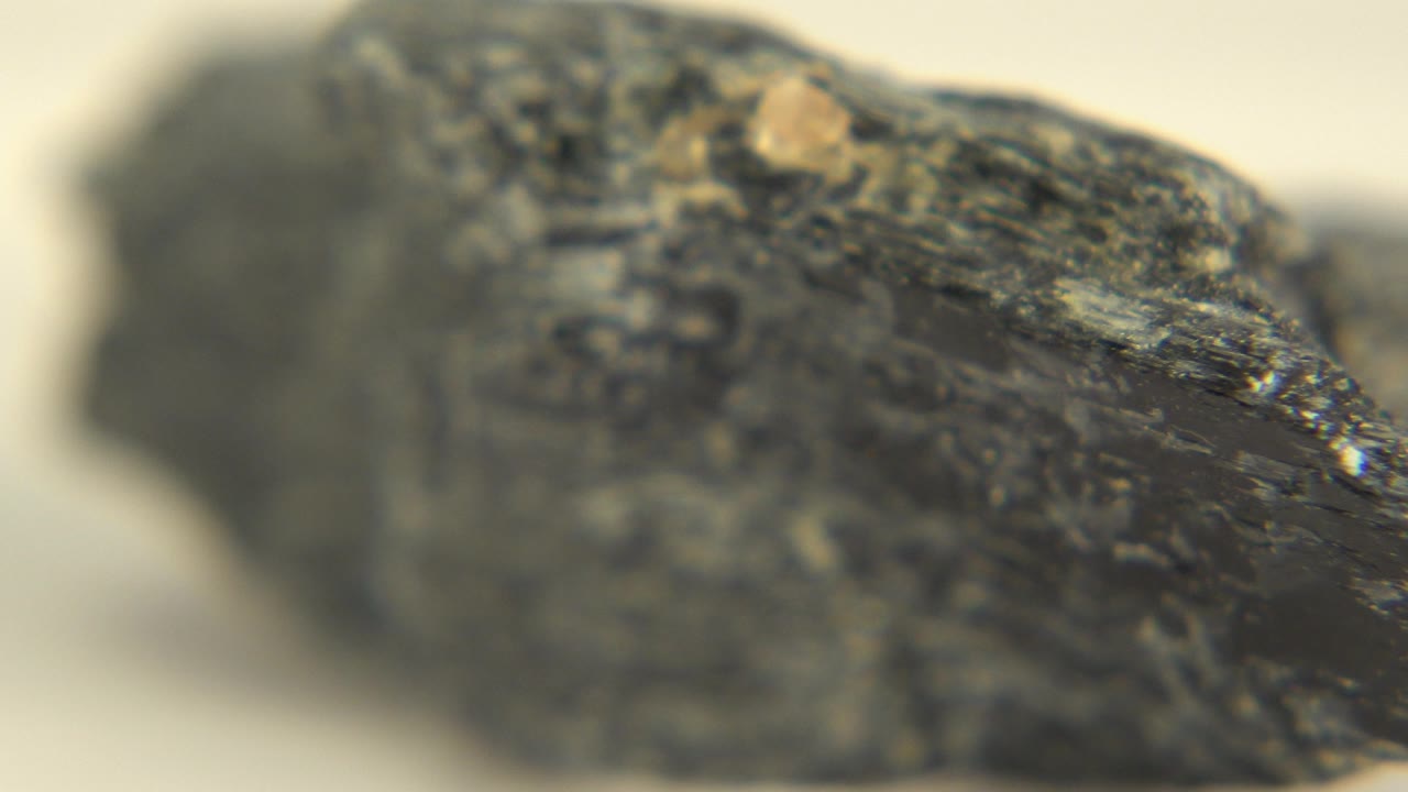 At 0:01, the rock remains close to the lens in Westminster, Colorado, with a brighter reflective ridge and no visible people.
