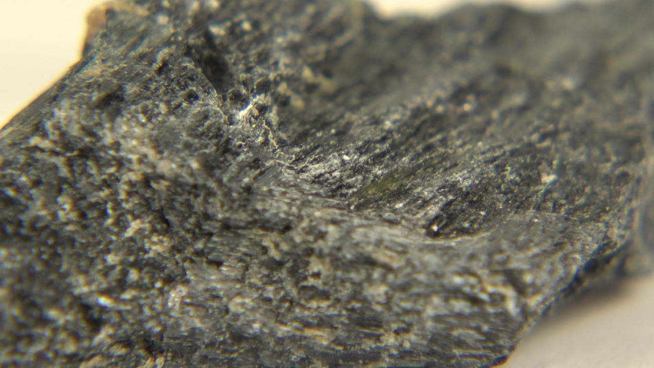 Macro-style view of the gray-black mineral surface in Westminster, Colorado, showing fractured texture and soft focus, with no visible people.