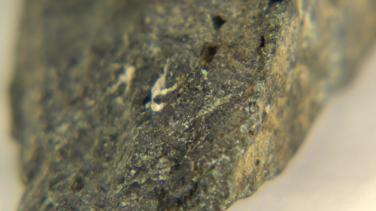 A rough gray-green stone fills the left and center of the frame in Westminster, Colorado, with a blurred pale background and no visible people.