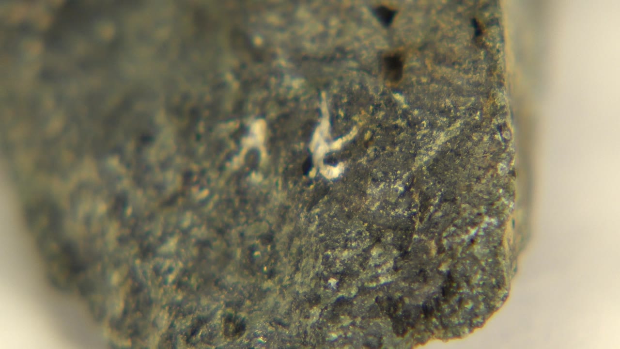 Textured stone face with a pale mark near the upper area.