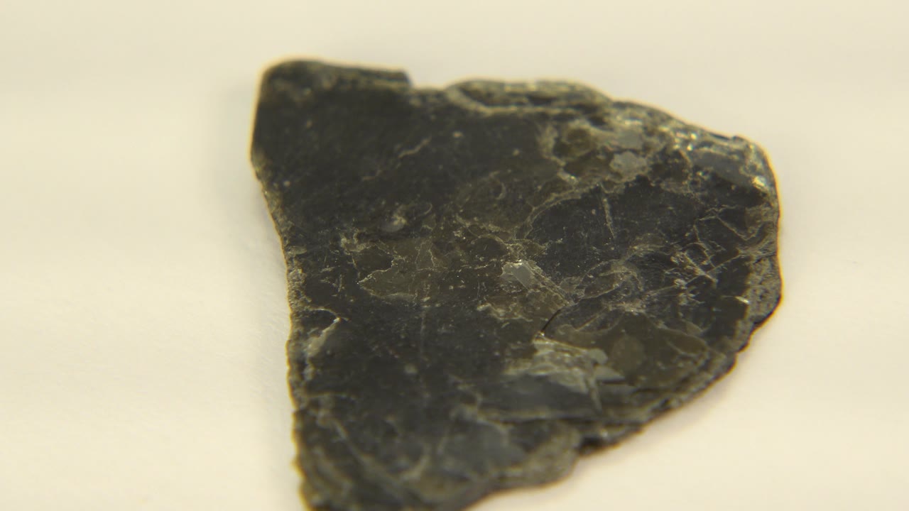 Rotated dark rock fragment on white background