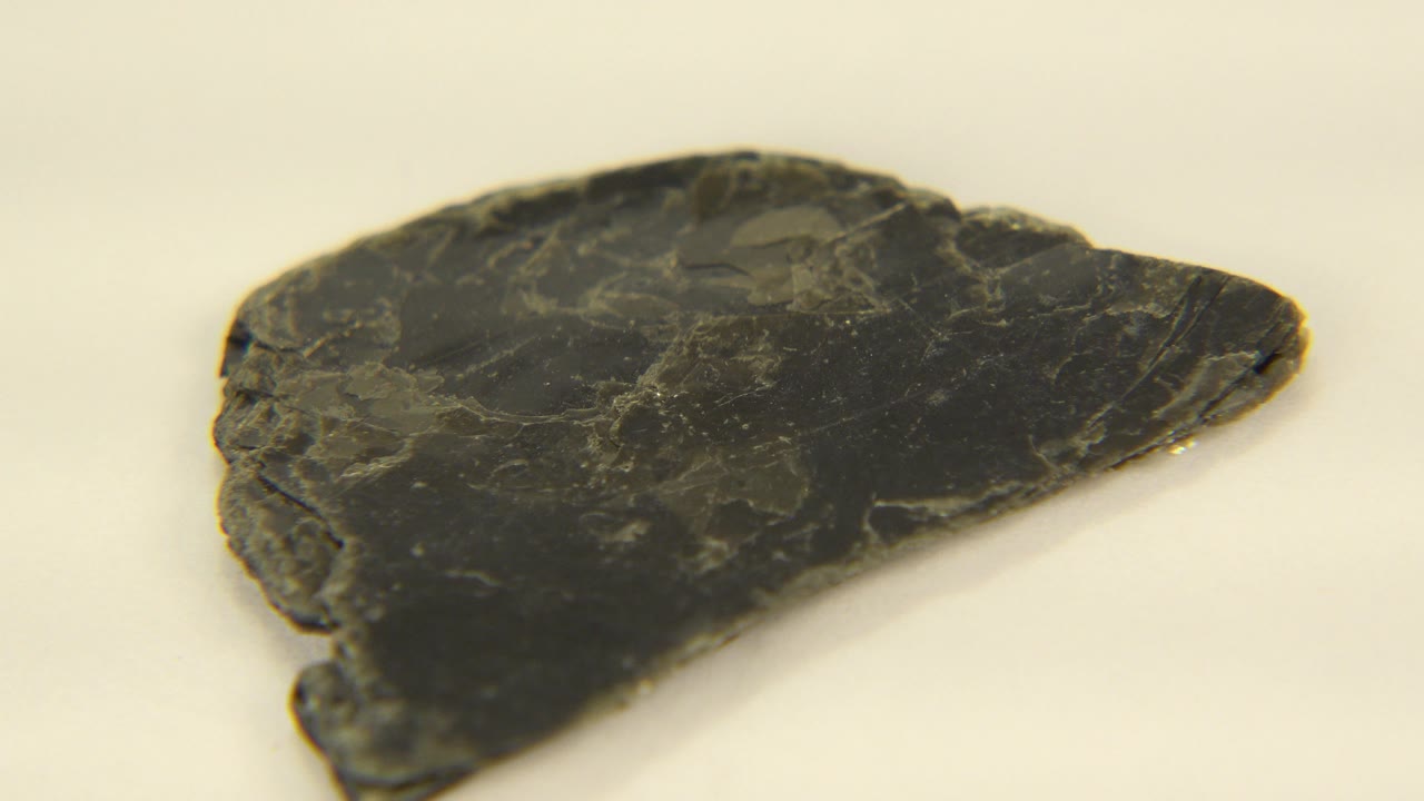 Close frame of a dark black and yellow quartz rock fragment on a pale indoor surface in Westminster, Colorado, with no visible people.