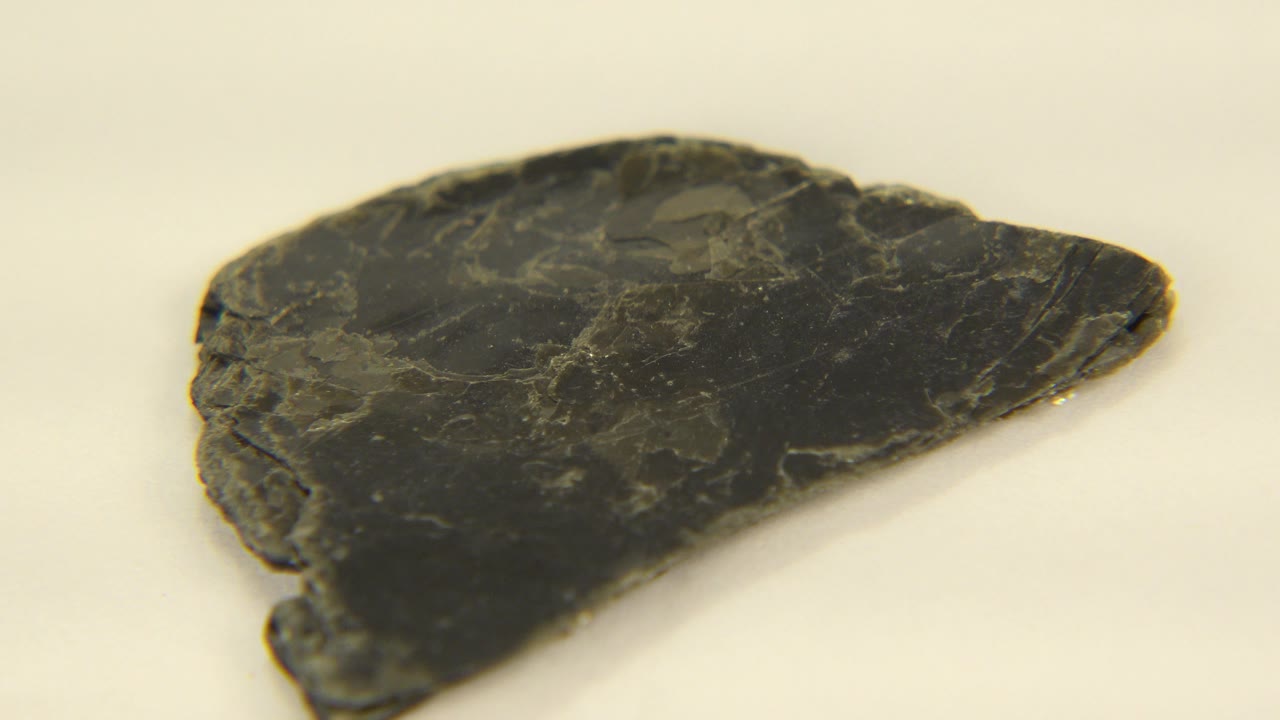 Close-up of the same dark quartz rock in Westminster, Colorado, showing its rough left edge and faint yellow mineral lines, with no visible people.