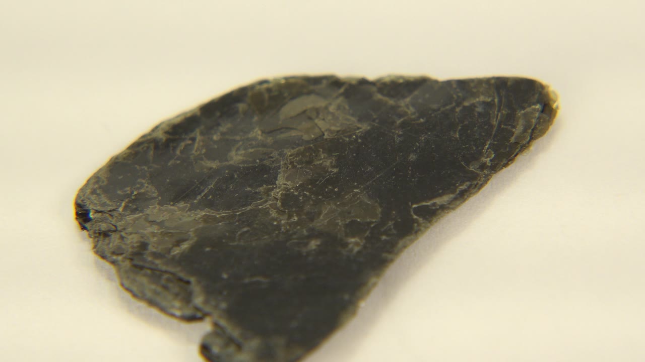 Angled dark rock specimen with pointed end