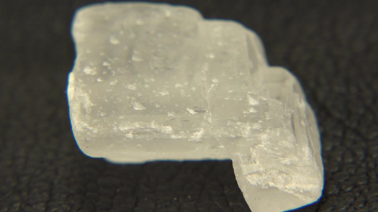 At the start of the Westminster, Colorado clip, a pale speckled rock sits broadside on a dark textured table with no visible people.