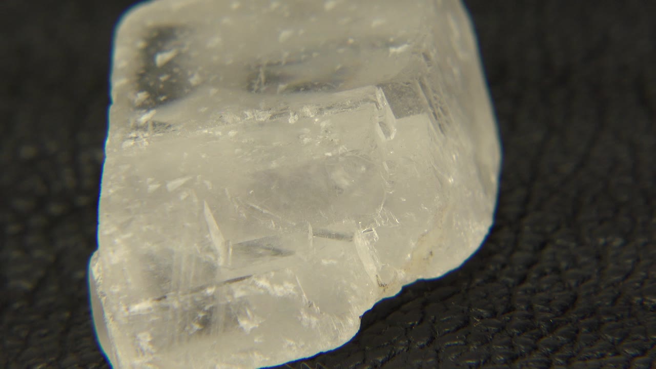 At 0:01, the quartz remains in tight close-up, showing a broad cloudy face, pale mineral specks, and no visible people in Westminster, Colorado.