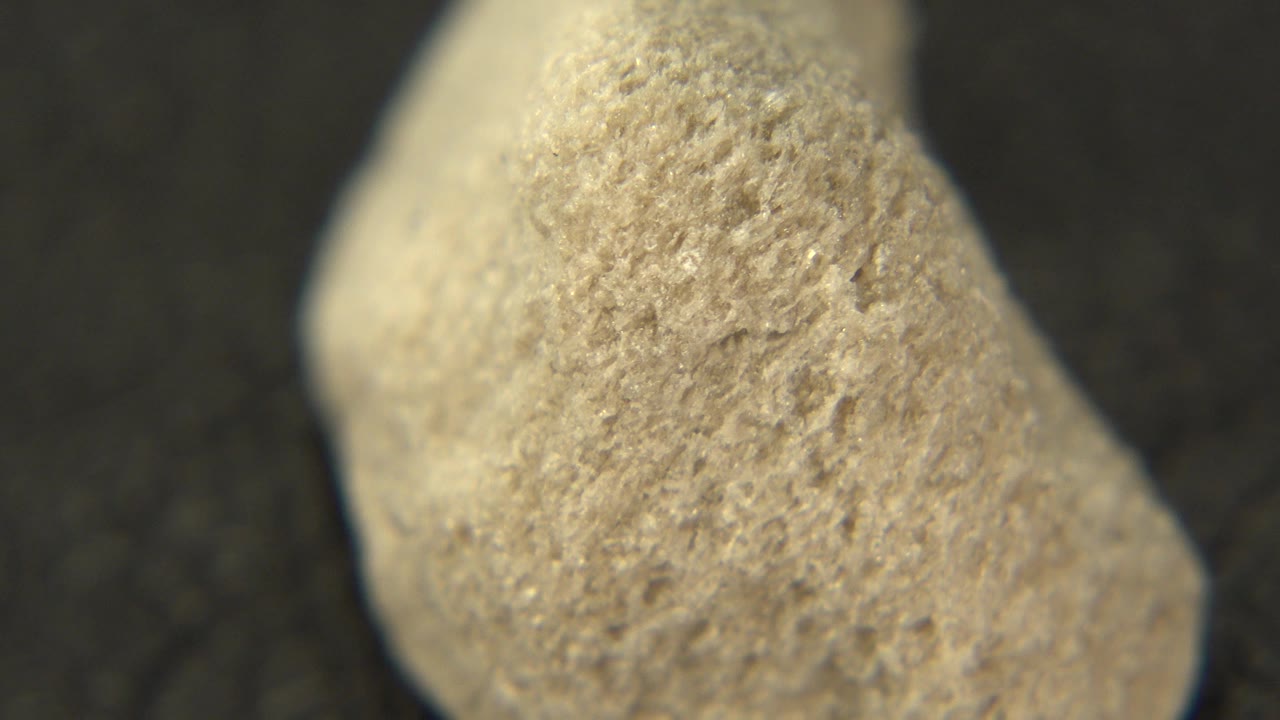 At 0:00, an off-white porous rock fills the frame on a black pedestal in Westminster, Colorado, with no visible people.