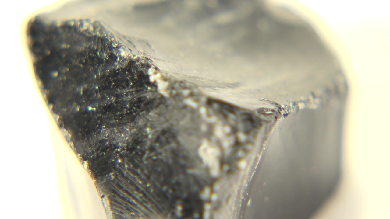 At 0:01 in Westminster, Colorado, the rock remains tightly framed with a dark triangular face, glossy highlights, and no visible people.