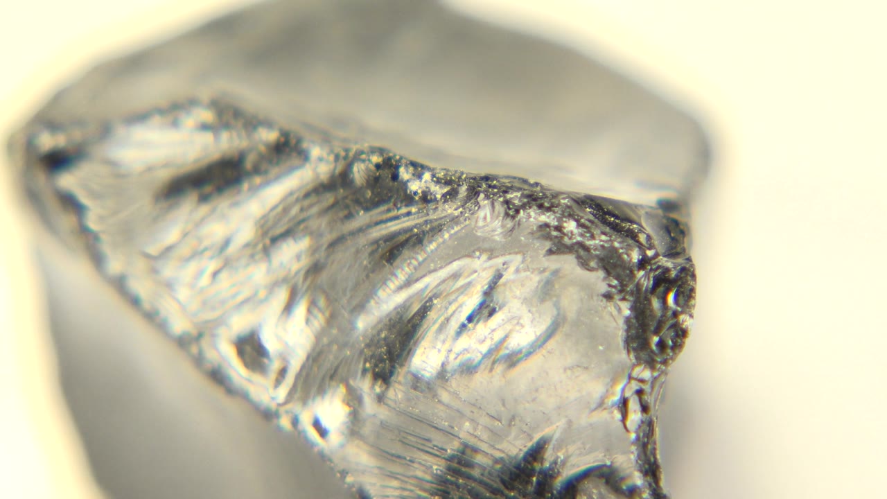 Translucent rock corner with scratched clear and black surfaces.