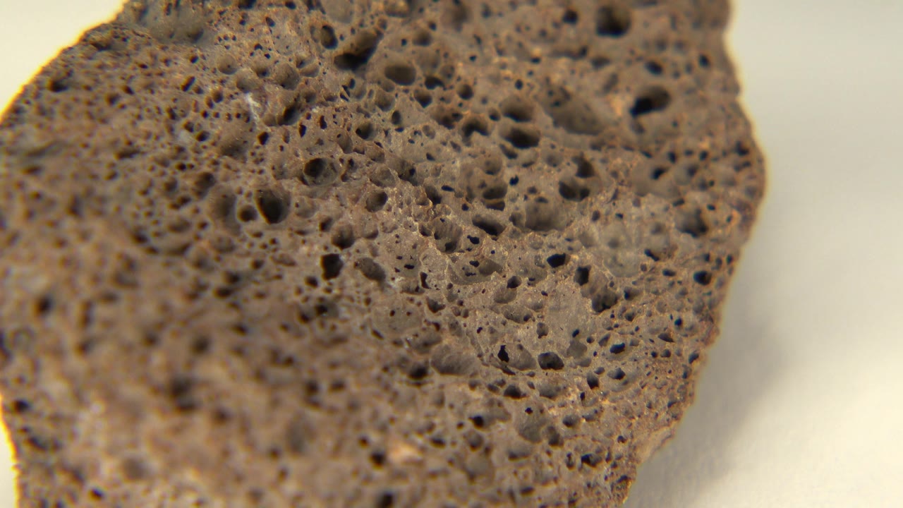 Rounded edge of pitted brown rock.