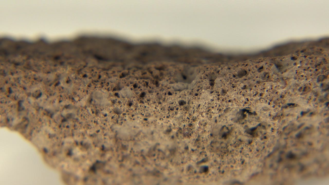 Porous brown rock edge on a pale background