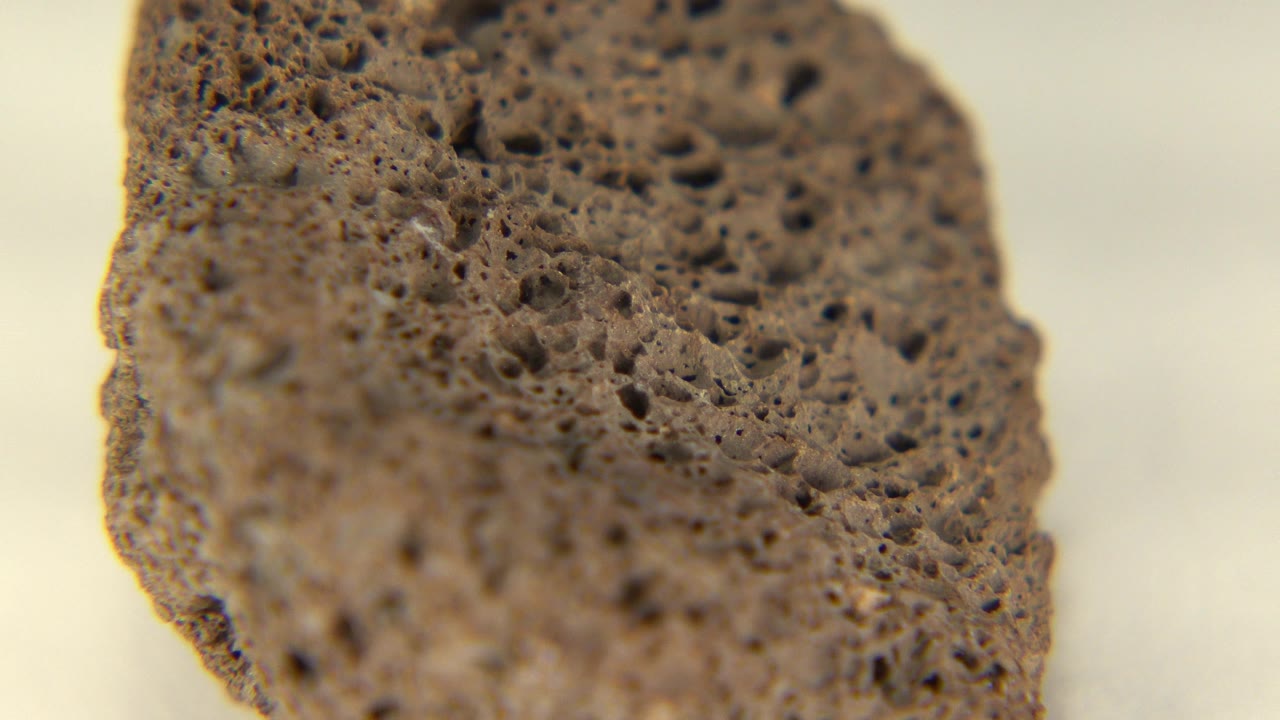 Close macro view of a brown tan porous rock in Westminster, Colorado footage, with the left edge sharpest and no visible people.