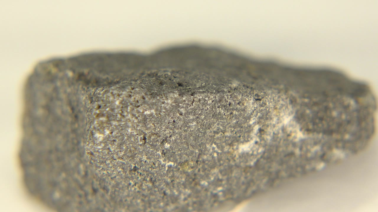 A rough gray rock fills the frame in Westminster, Colorado, with white specks across its front face, shallow focus at the edges, and no visible people.
