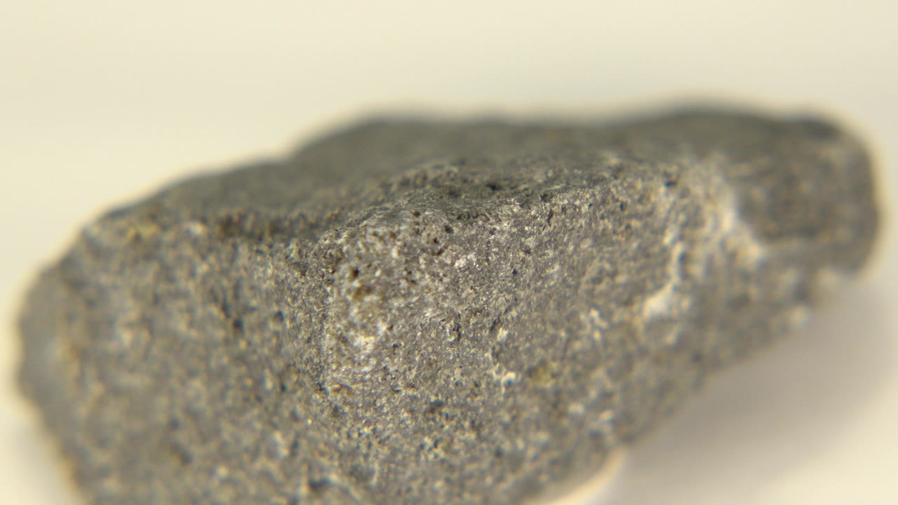 Angled gray rock with a rough speckled top edge.