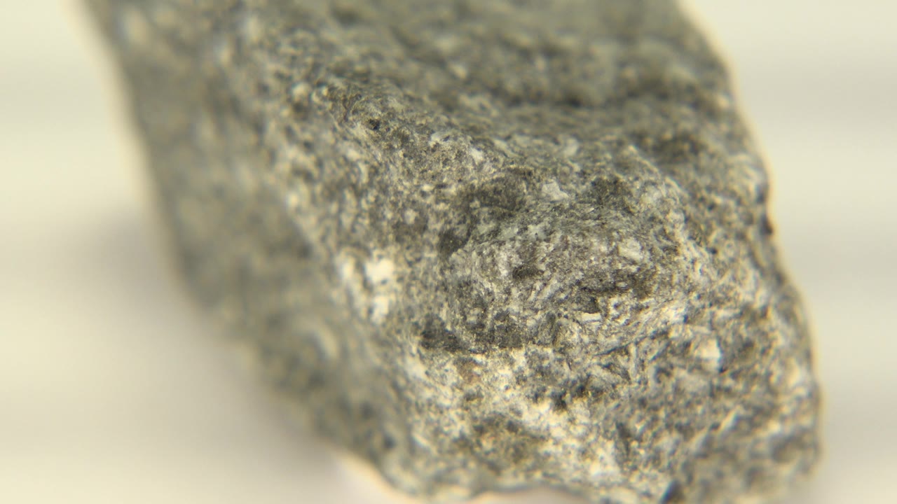 A gray stone end fills the frame in Westminster, Colorado footage, showing granular edges, pale background blur, and no visible people.