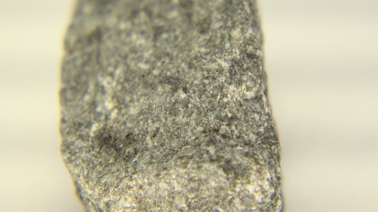 Vertical end of a gray stone piece in soft warm light.