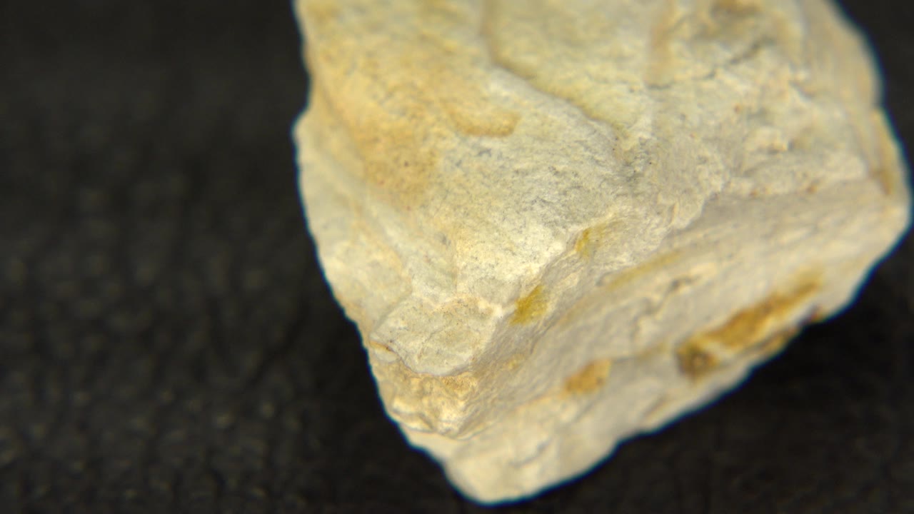 The sandstone quartz remains close to the lens on black felt in Westminster, Colorado, with a broad pale top face, tan streaking, and no visible people.