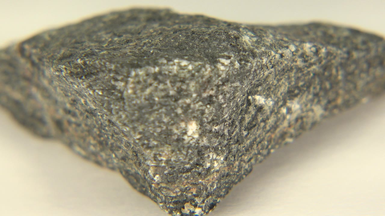 At 0:00, a gray speckled stone fills the foreground on a pale surface in Westminster, Colorado, with no visible people.