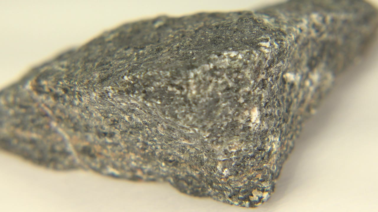 Angled close-up of a gray rock with a pointed edge.